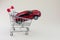 red toy car in shopping cart