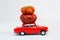 Red toy car with small pumpkins on the roof