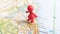 A red toy figure standing over Newcastle Upon Tyne on a map of England portrait