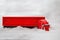 A red toy truck rides in the winter on a snowy road making its way through the snowdrifts. The holiday comes to us. Side view