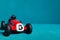 Red toy vintage racing car with number five close up on a blue fabrics background