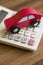 Red Toy Wooden Car On Calculator To Illustrate Cost Of Motoring