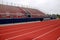 Red track in front of red and blue bleachers