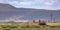 Red tractor on a field near the base of a mountain