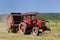 A red tractor and hay baler