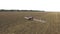 Red tractor plowing the field corn. aerial shot