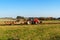 Red tractor pole field. Autumn field work. Life on the farm. Agricultural landscape in the Czech Republic.