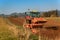 Red tractor pole field. Autumn field work. Life on the farm. Agricultural landscape in the Czech Republic.