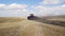 A red tractor with a reverse plow plows a field.