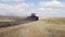 A red tractor with a reverse plow plows a field.