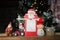 red tractor, souvenir figurines of snowman and Santa, festive notebook on background of Christmas tree