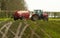 Red tractor spreading spreading slurry on fields