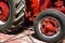 Red tractor tied down to a trailer with come along chain pullers