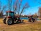 Red tractors trucks in spring city park. Cleaning. Early spring. Works. Sunny spring day.