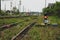 Red traffic light. Green natural railway background. On the right and on the left are the railway tracks