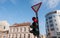 Red traffic light for vehicles and cars on the crosswalk on the street in the city close up with buildings and blue sky background