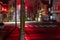 Red traffic lights on empty intersection at night after rain