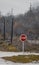 Red traffic sign with \'stop\' on it on the road with bare trees in the background