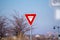 Red traffic Yield sign alongside a road