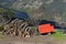 Red trailer and a pile of firewood on a rural yard