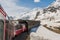 Red train from the company tunneling in the Alps.