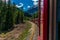 Red train slowly climbing to the Bernina Pass in the Swiss Alps