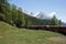 Red train slowly climbing to the Bernina Pass in the Swiss Alps