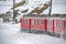 Red train in the snow in swiss alps