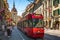 Red tram going to Ostring and Kafigturm or prison tower with people in Marktgasse street in Bern old town Switzerland