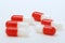 Red and transparent medical pills capsules on white background