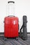 Red travelling suitcase and camera tripod
