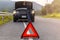 Red triangle sign on road for warning have car with breakdown open car hood and man fixing a car