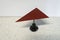 Red triangular metal plate is balancing on a needle