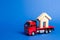 A red truck transports a wooden house. Concept of transportation and cargo shipping, moving company. Construction of new houses