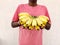 Red tshirt south Indian man holding a cluster of bananas.