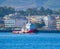 Red Tugboat and Sunny Summer Coast With Town