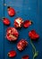 Red tulip, pomegranate with seeds on dark blue wooden background, flat layout
