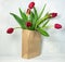 Red tulips in brown sack