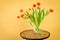 Red tulips in a vase on mosaic table.