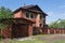 Red two-storey brick house with  garage behind  high fence