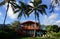 Red Two Story Beach House with tall coconut trees