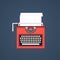 Red typewriter isolated on dark blue background