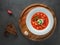 Red ukrainian borscht in white plate on wooden plate with dark bread and red pepper