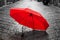 Red umbrella on cobblestone street in the old town. Wind and rain