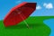 Red umbrella in grass