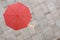 Red umbrella and a hand of man standing on stone floor and hand