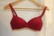 Red underwire T-shirt bra with white towel background.