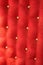 Red upholstery background with gold buttons