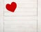 A Red Valentines Day Heart on Rustic White Wood Boards Background with room or space for copy, text or your words.  It`s a horizo