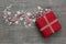 Red valentines present with checked ribbon and hearts on grey wooden background.